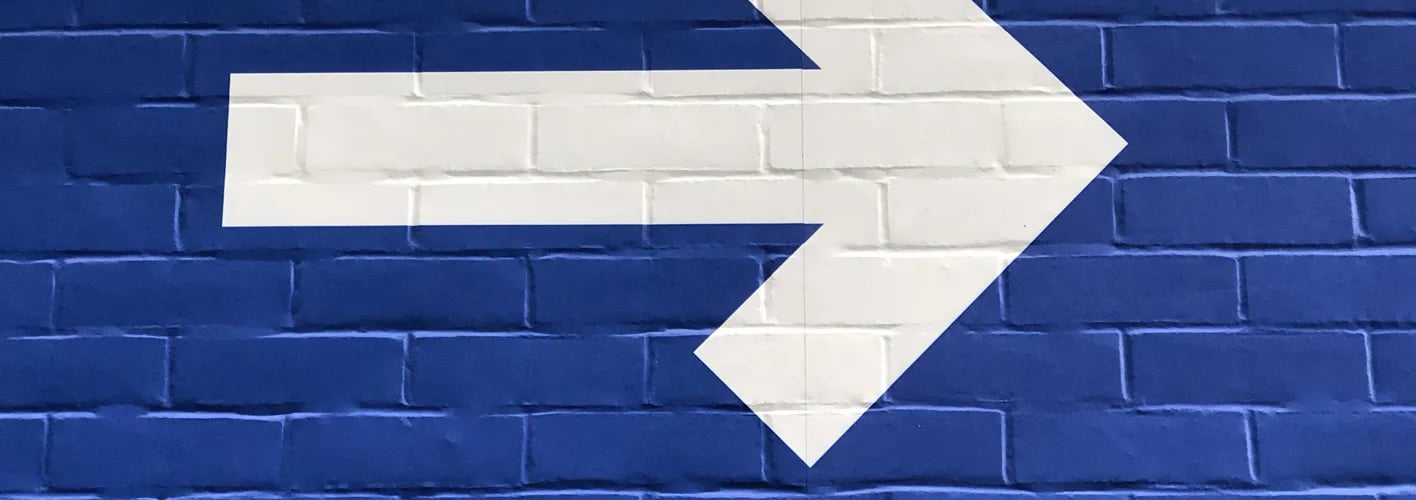Blog_Inspirational_ Blue Brick Wall with White Arrow Pointing Right