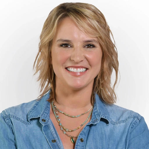 Headshot of Allison Dyer, a white woman with shoulder-length blonde hair wearing a denim shirt and a multi-strand beaded necklace (Web Optimized)