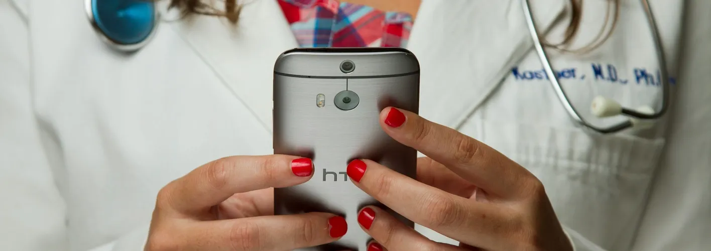 Blog_Healthcare_closeup view of female doctor's hands holding mobile phone (Web Optimized)